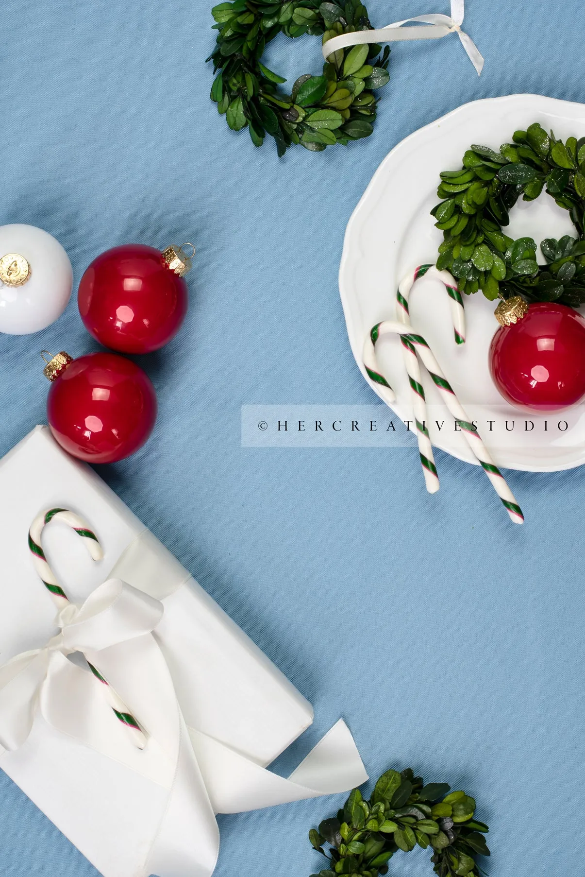 Red Ornaments & Holiday Gift on Sky Blue Background