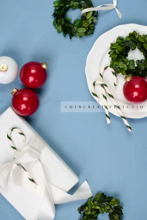 Red Ornaments & Holiday Gift on Sky Blue Background