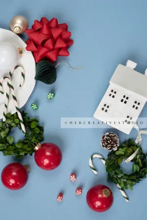 Red Ornaments, Holiday Home & Wreath on Sky Blue Background